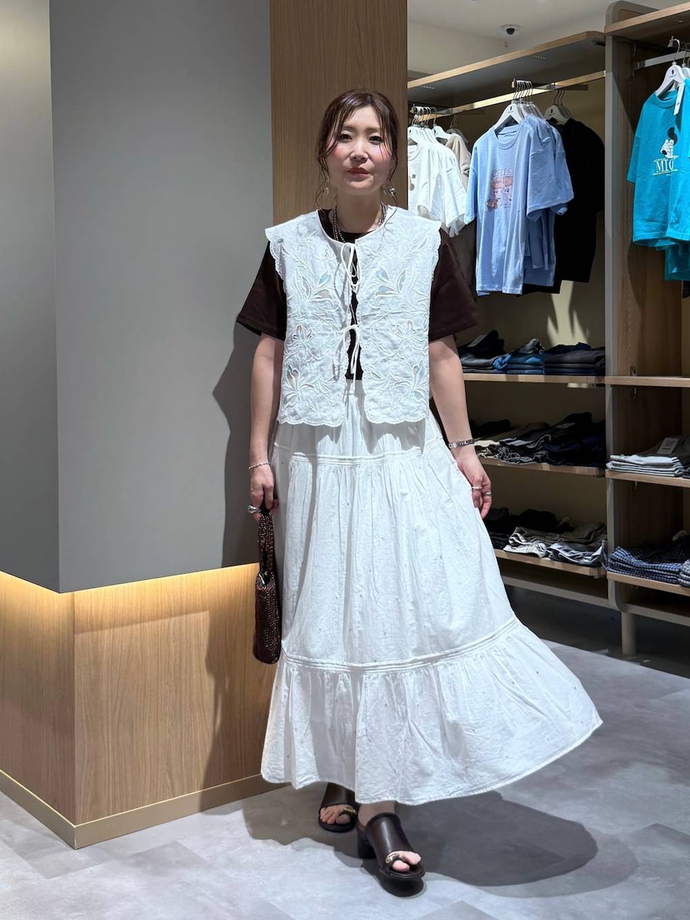ホワイト系のベスト、ホワイト系のスカート、ブラウン系のTシャツ/カットソーを着用したレディースの夏コーディネートの1枚目の写真