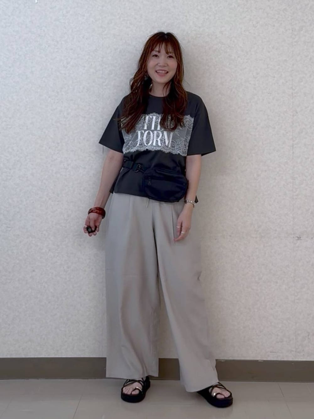ベージュ系のその他パンツ、ブラック系のサンダル、ブラック系のボディバッグ/ウエストポーチを着用したレディースの夏コーディネートの1枚目の写真