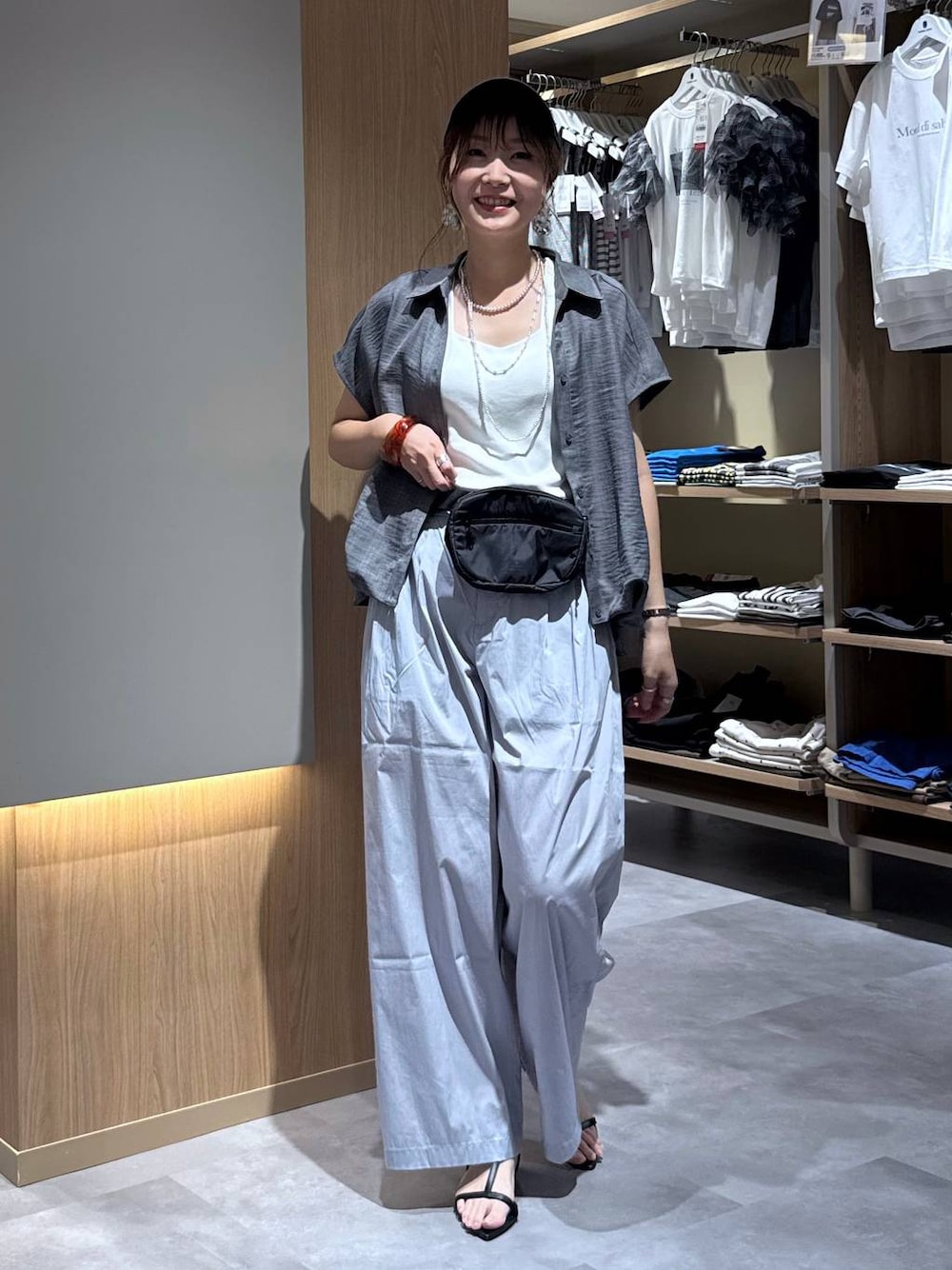 グレー系のその他パンツ、ホワイト系のタンクトップ、ブラック系のボディバッグ/ウエストポーチを着用したレディースの夏コーディネートの1枚目の写真