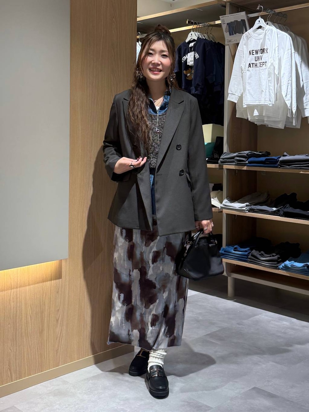 ブラック系のショルダーバッグ、ブラック系のローファー、ブルー系のシャツ/ブラウスを着用したレディースの春コーディネートの1枚目の写真