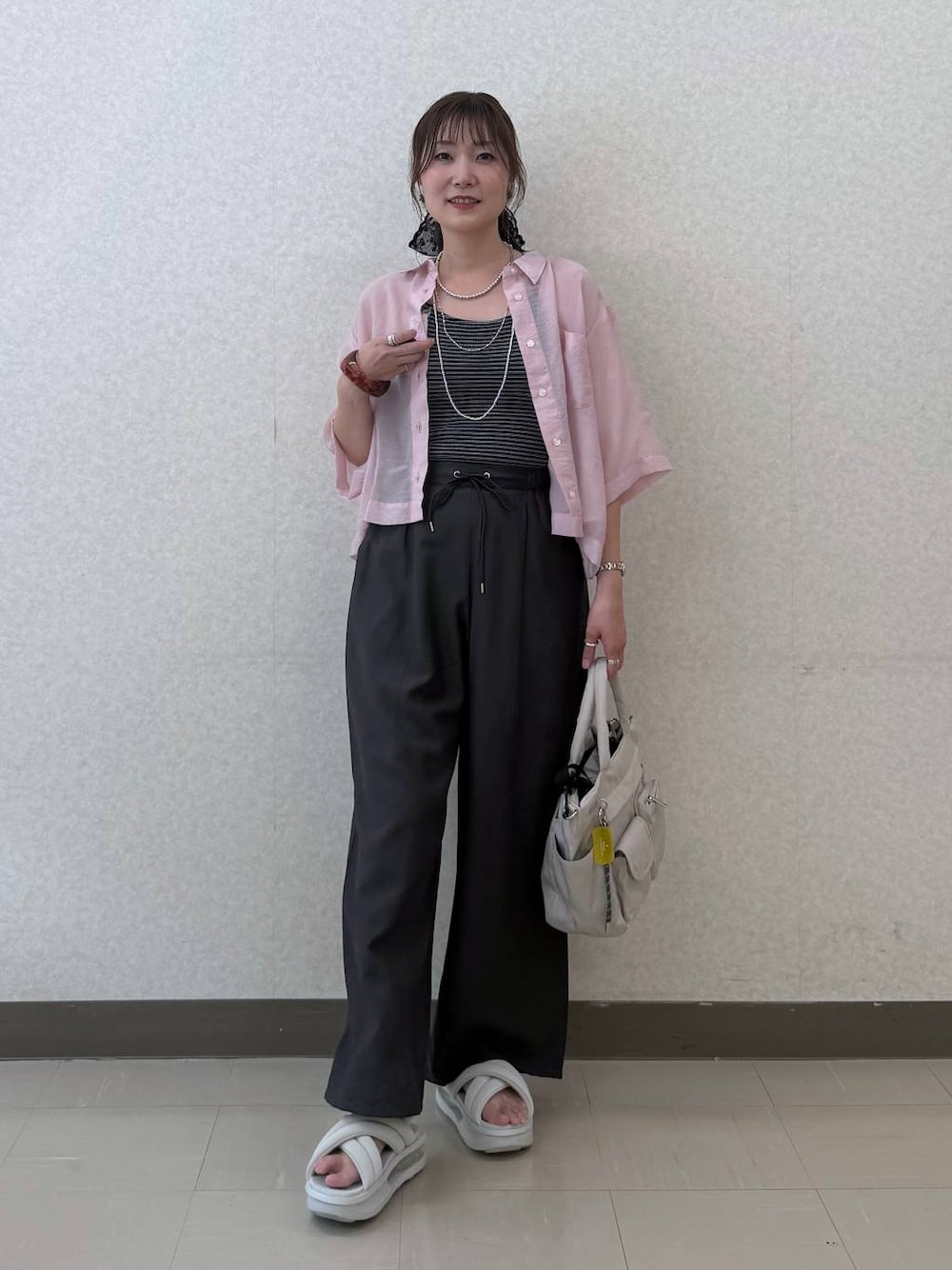 ブラック系のトートバッグ、ブラウン系のその他パンツ、ピンク系のシャツ/ブラウスを着用したレディースの夏コーディネートの1枚目の写真