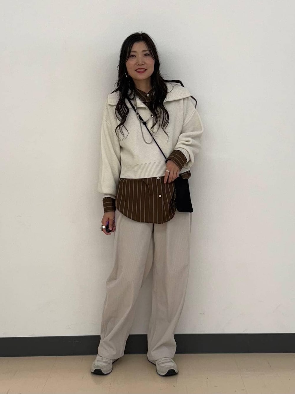 ブラウン系のシャツ/ブラウス、グレー系のその他パンツ、ホワイト系のニット/セーターを着用したレディースの冬コーディネートの1枚目の写真