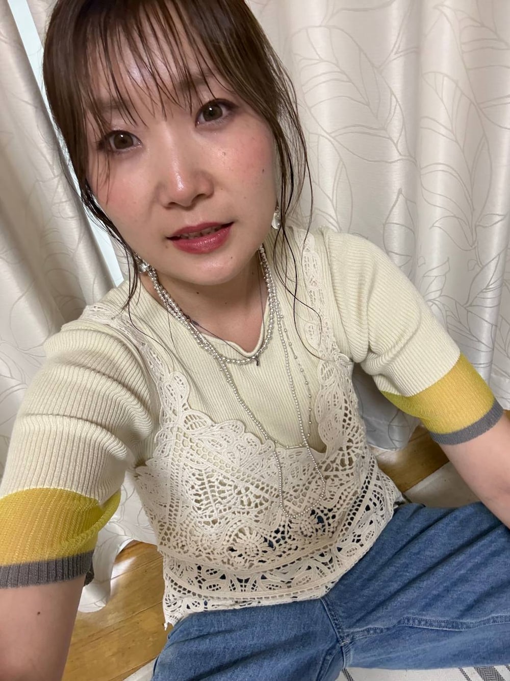 イエロー系のニット/セーター、シルバー系のネックレスを着用したレディースの夏コーディネートの1枚目の写真