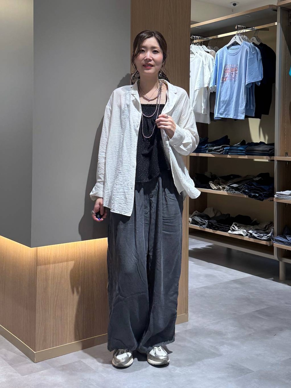 ベージュ系のパーカー、ブラック系のデニムパンツ、ホワイト系のシャツ/ブラウスを着用したレディースの春コーディネートの1枚目の写真