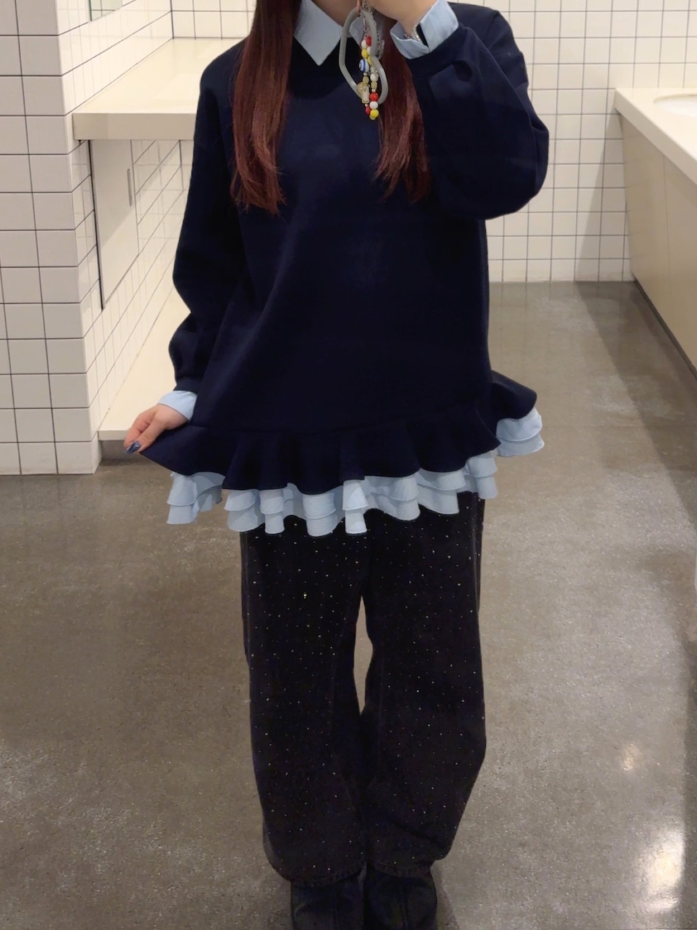 ブルー系のチュニック、ブラック系のデニムパンツを着用したレディースの冬コーディネートの1枚目の写真