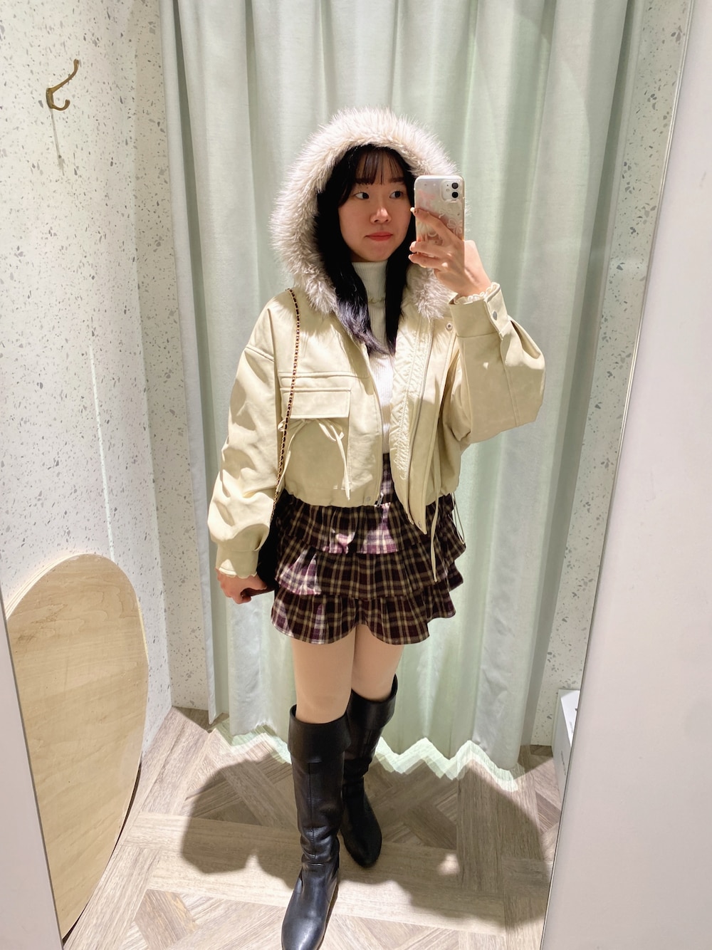 ブラウン系のショルダーバッグ、ホワイト系のニット/セーター、ホワイト系のブルゾンを着用したレディースの秋コーディネートの1枚目の写真