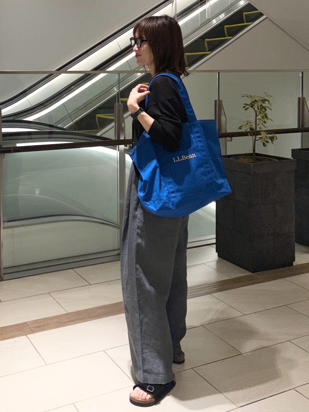 ブラック系のカーディガン/ボレロ、ブルー系のトートバッグ、ブラック系のその他パンツを着用したレディースの夏コーディネートの1枚目の写真