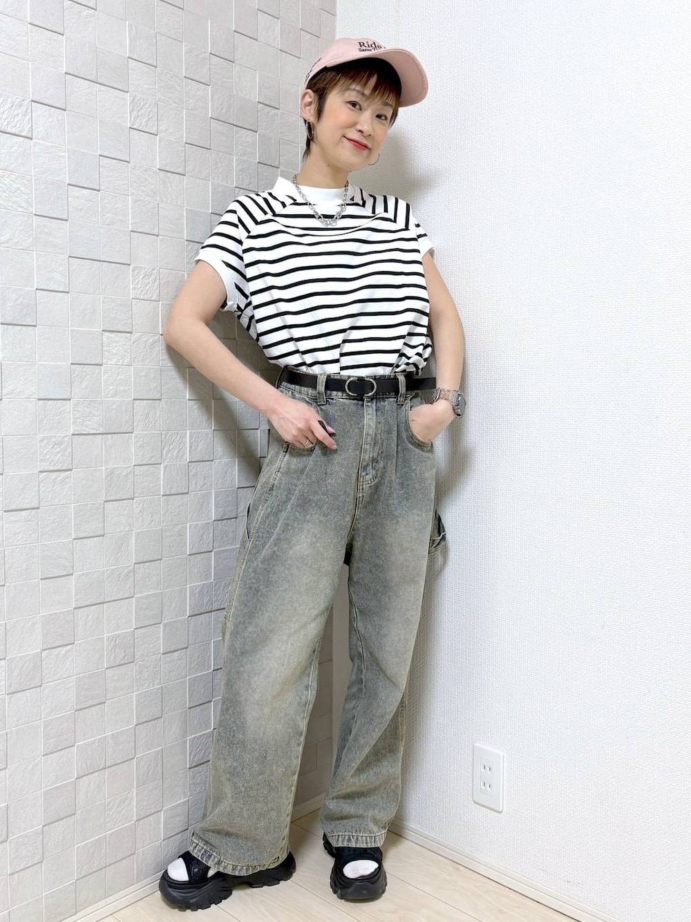 ブラック系のベルトを着用したレディースの春コーディネートの1枚目の写真