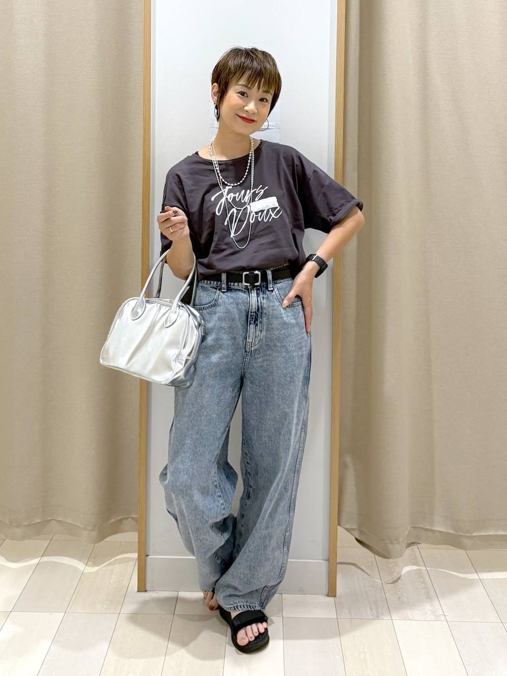 ブルー系のデニムパンツ、ブラック系のTシャツ/カットソー、グレー系のボストンバッグを着用したレディースの夏コーディネートの1枚目の写真