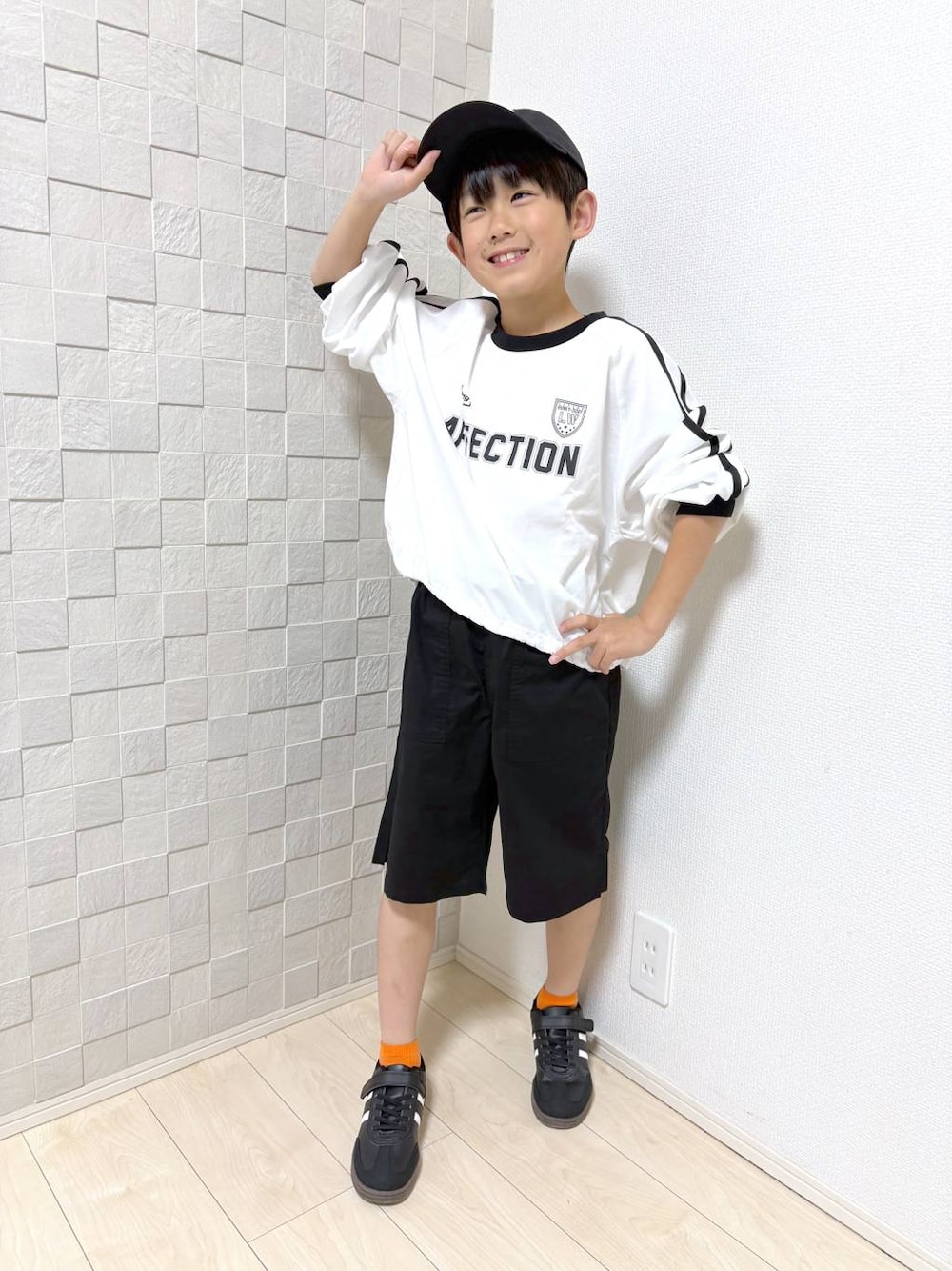 ブラック系のその他パンツ、ホワイト系のTシャツ/カットソーを着用したキッズの春コーディネートの1枚目の写真