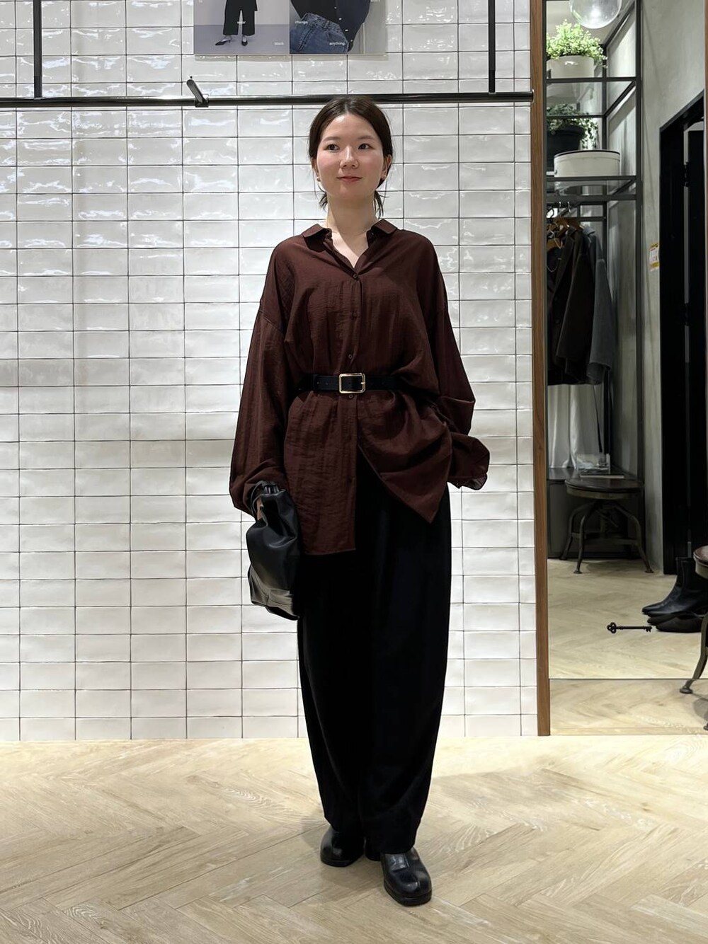 ブラック系のスラックス、ブラウン系のシャツ/ブラウス、ブラック系のベルトを着用したレディースの秋コーディネートの1枚目の写真