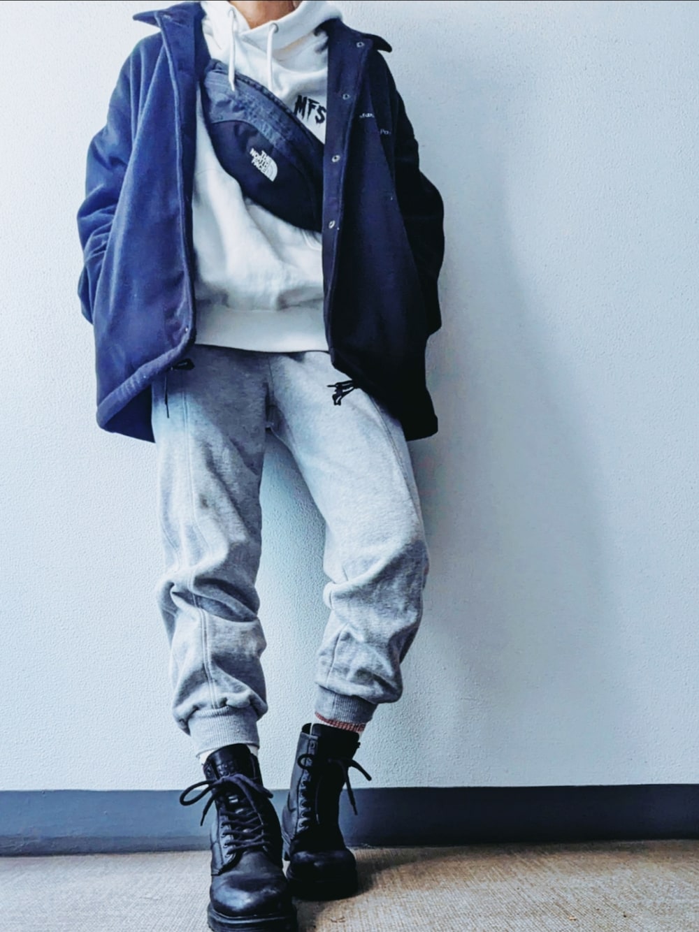 グレー系のスウェットパンツ、ブラック系のブーツ、ホワイト系のパーカーを着用したレディースの冬コーディネートの1枚目の写真