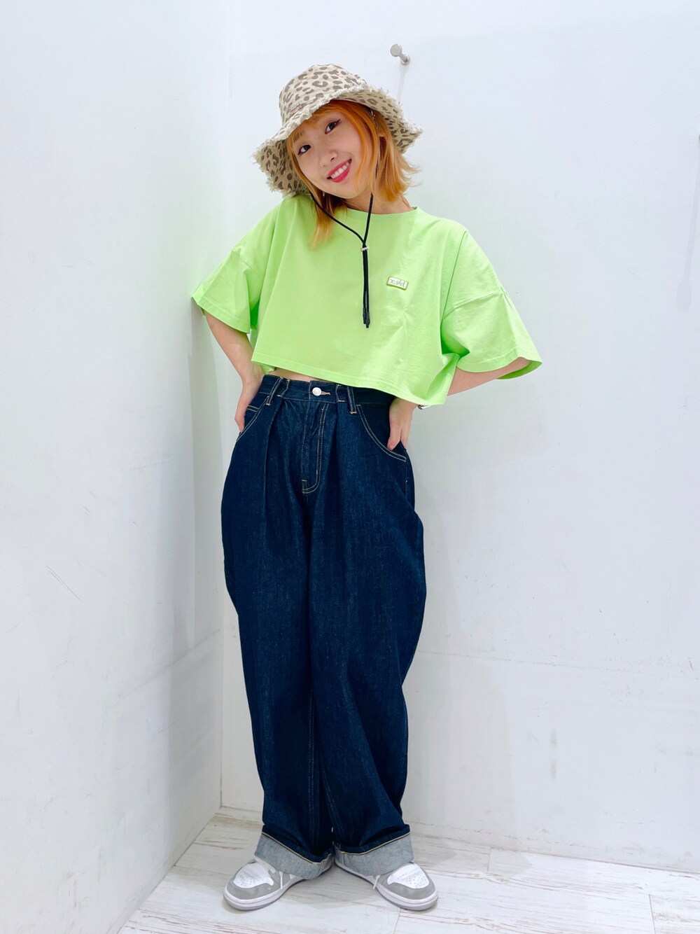 グリーン系のTシャツ/カットソー、ブルー系のデニムパンツ、ベージュ系のハットを着用したレディースの夏コーディネートの1枚目の写真