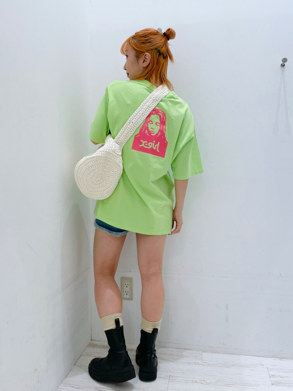 ホワイト系のショルダーバッグ、グリーン系のTシャツ/カットソーを着用したレディースの夏コーディネートの1枚目の写真