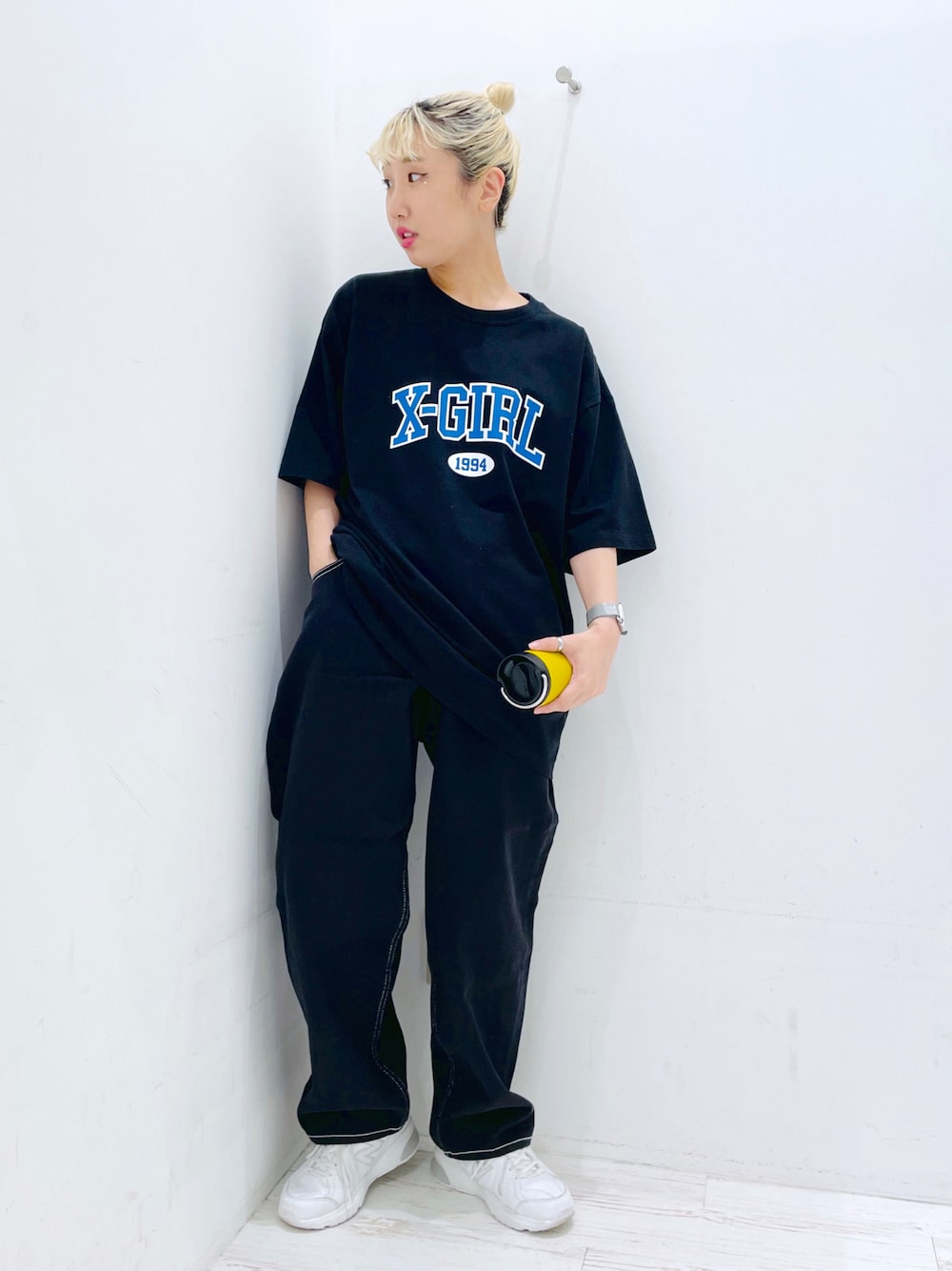 ブラック系のその他パンツ、ブラック系のTシャツ/カットソー、イエロー系のグラス/マグカップ/タンブラーを着用したレディースの春コーディネートの1枚目の写真