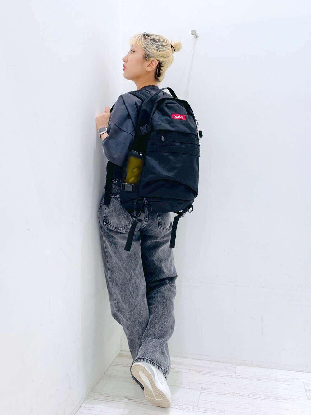 ブラック系のデニムパンツ、レッド系のバックパック/リュック、イエロー系のグラス/マグカップ/タンブラーを着用したレディースの春コーディネートの1枚目の写真