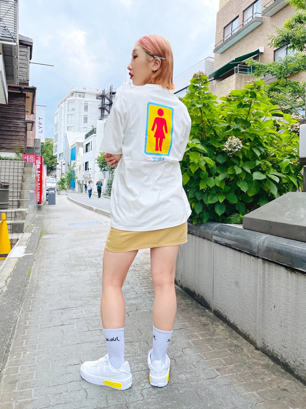 ホワイト系のTシャツ/カットソー、ベージュ系のスカートを着用したレディースの夏コーディネートの1枚目の写真