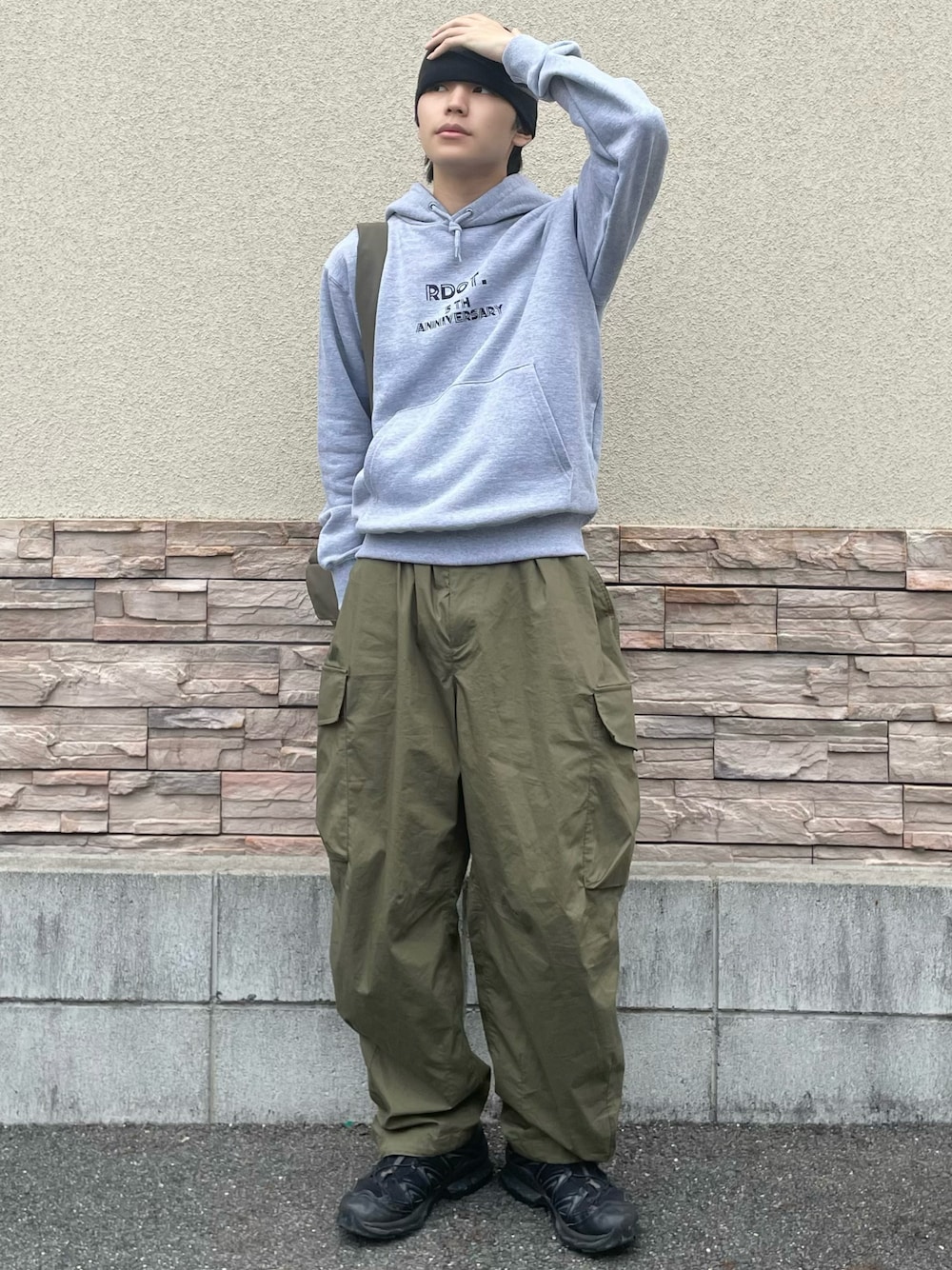 グリーン系のカーゴパンツ、グリーン系のショルダーバッグ、ブラック系のスニーカーを着用したメンズの秋コーディネートの1枚目の写真