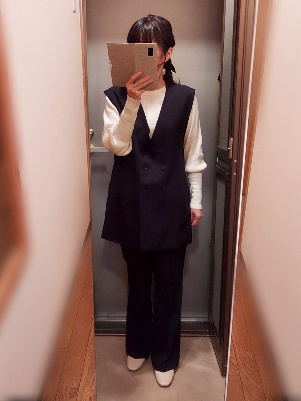 ブラック系のスラックス、ホワイト系のニット/セーター、ホワイト系のローファーを着用したレディースの春コーディネートの1枚目の写真