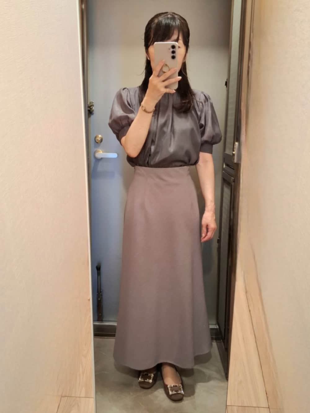 グレー系のシャツ/ブラウス、グレー系のスカート、ベージュ系のパンプスを着用したレディースの夏コーディネートの1枚目の写真