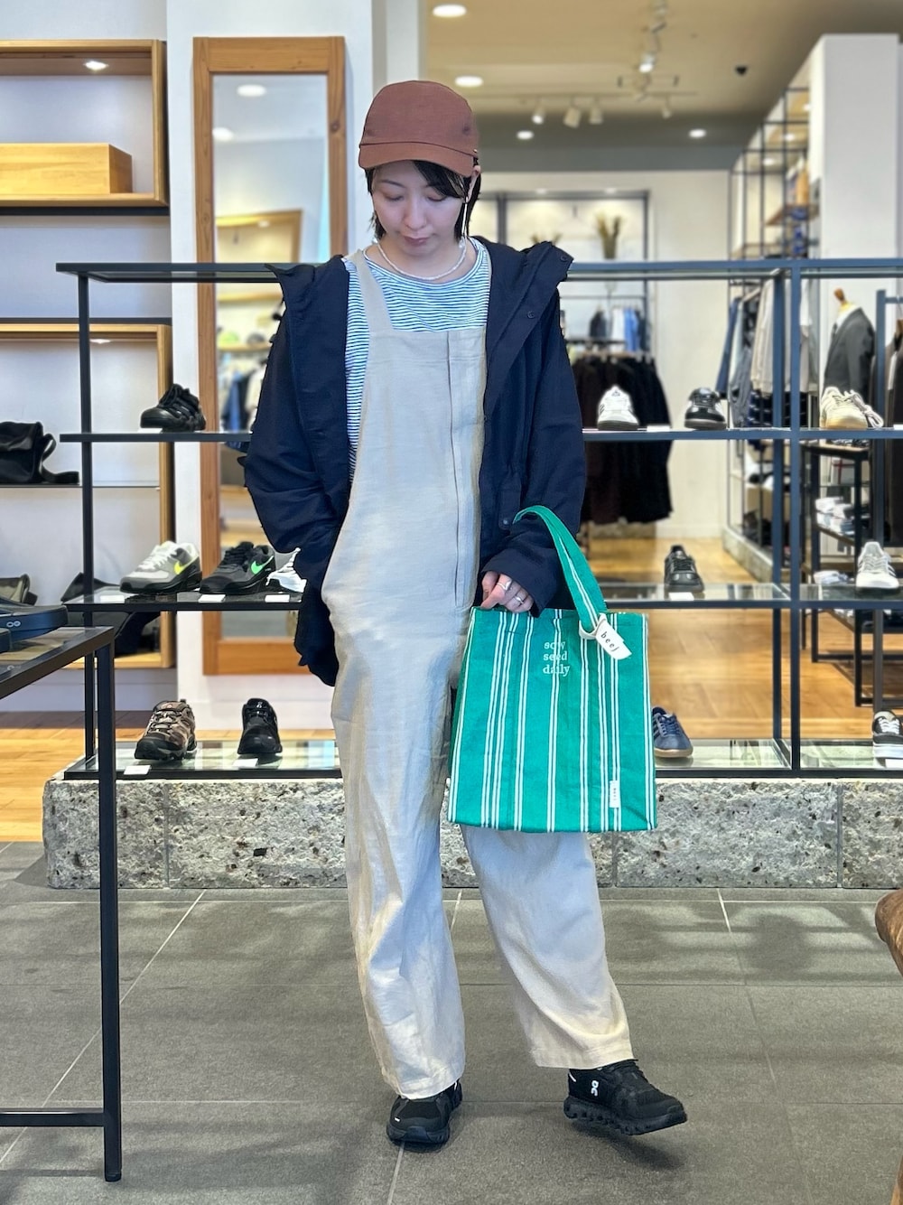 ホワイト系のTシャツ/カットソー、ブラック系のスニーカー、ブルー系のマウンテンパーカーを着用したレディースの春コーディネートの1枚目の写真