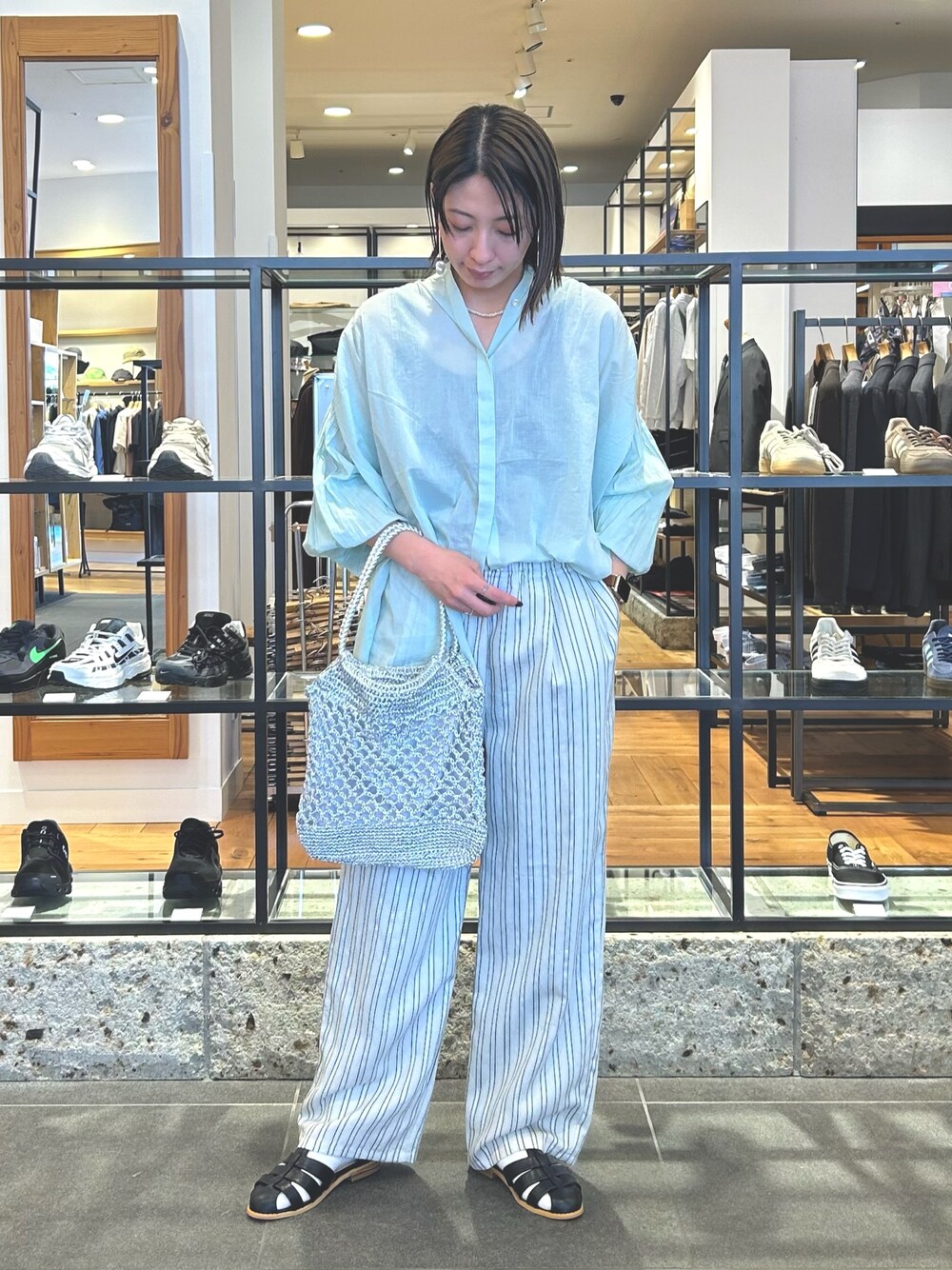 グレー系のその他パンツ、シルバー系のトートバッグ、ブラック系のサンダルを着用したレディースの春コーディネートの1枚目の写真