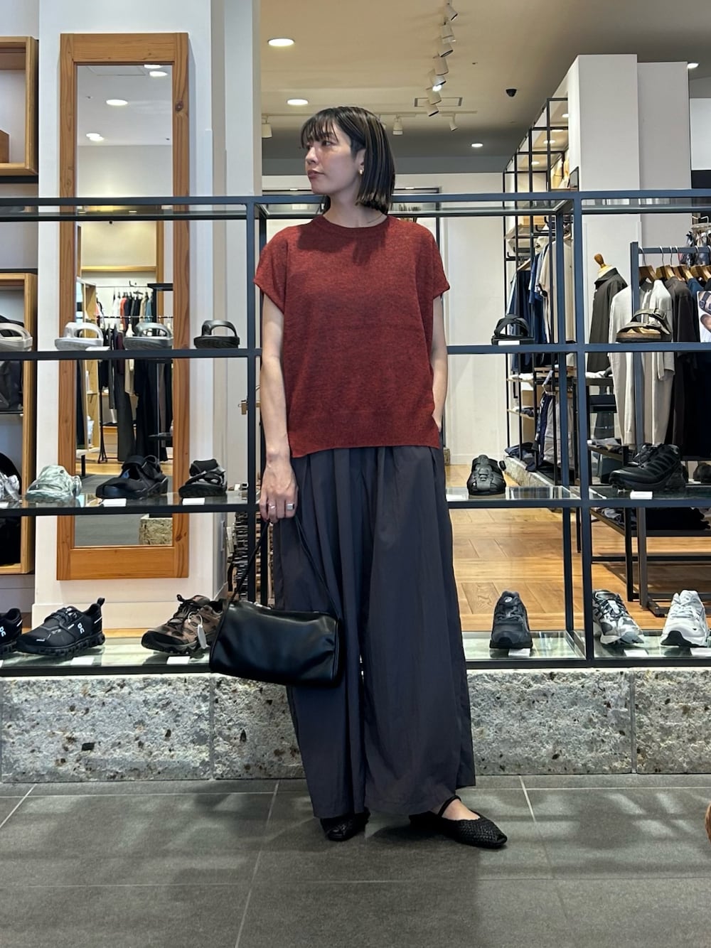 レッド系のその他トップス、グレー系のその他パンツ、ブラック系のハンドバッグを着用したレディースの夏コーディネートの1枚目の写真