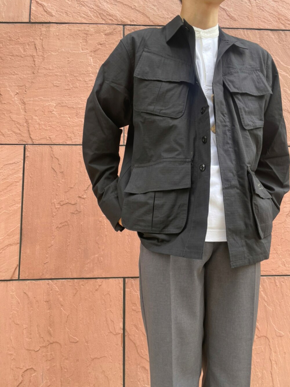 ブラック系のミリタリージャケット、グレー系のその他パンツ、ホワイト系のシャツ/ブラウスを着用したメンズの夏コーディネートの1枚目の写真