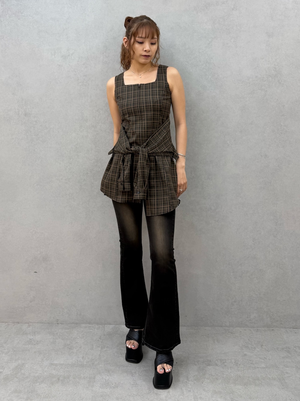 ブラウン系のワンピース、ブラック系のデニムパンツ、ブラック系のサンダルを着用したレディースの夏コーディネートの1枚目の写真