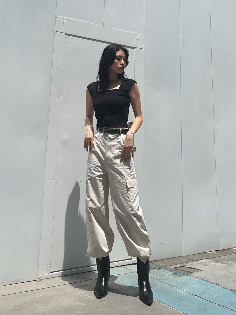 ホワイト系のカーゴパンツ、ブラック系のブーツ、ブラック系のベルトを着用したレディースの夏コーディネートの1枚目の写真