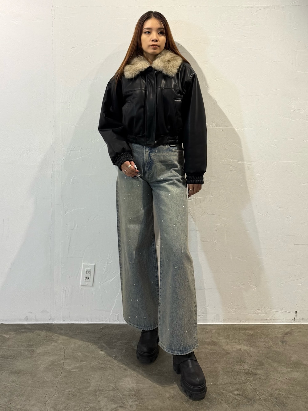 ブラック系のブルゾン、ブルー系のデニムパンツ、ブラック系のブーツを着用したレディースの冬コーディネートの1枚目の写真