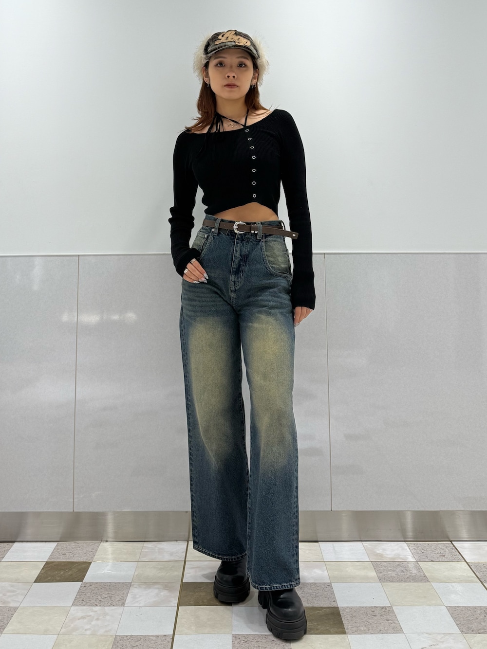 ブラック系のニット/セーター、ブルー系のデニムパンツ、ブラック系のブーツを着用したレディースの冬コーディネートの1枚目の写真