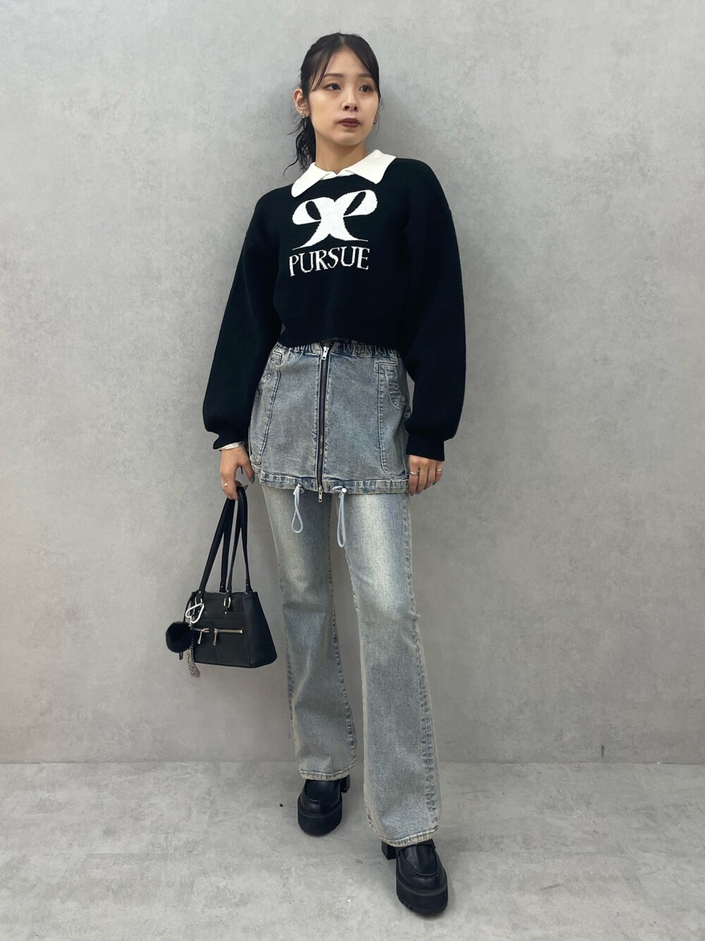 ブラック系のニット/セーター、ブルー系のデニムパンツ、ブラック系のショルダーバッグを着用したレディースの夏コーディネートの1枚目の写真