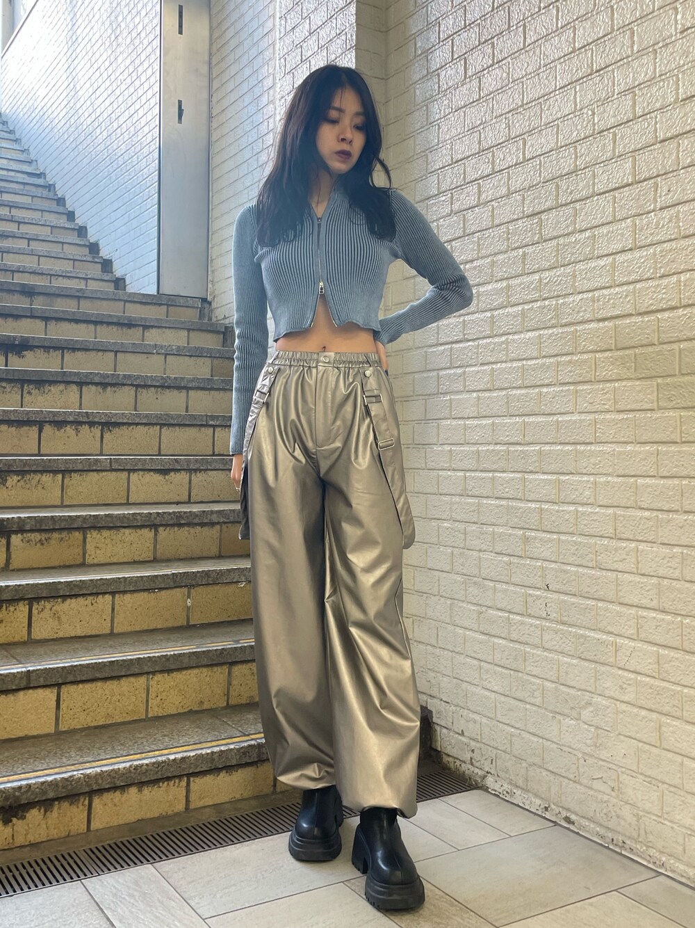 ブルー系のニット/セーター、シルバー系のその他パンツ、ブラック系のブーツを着用したレディースの冬コーディネートの1枚目の写真