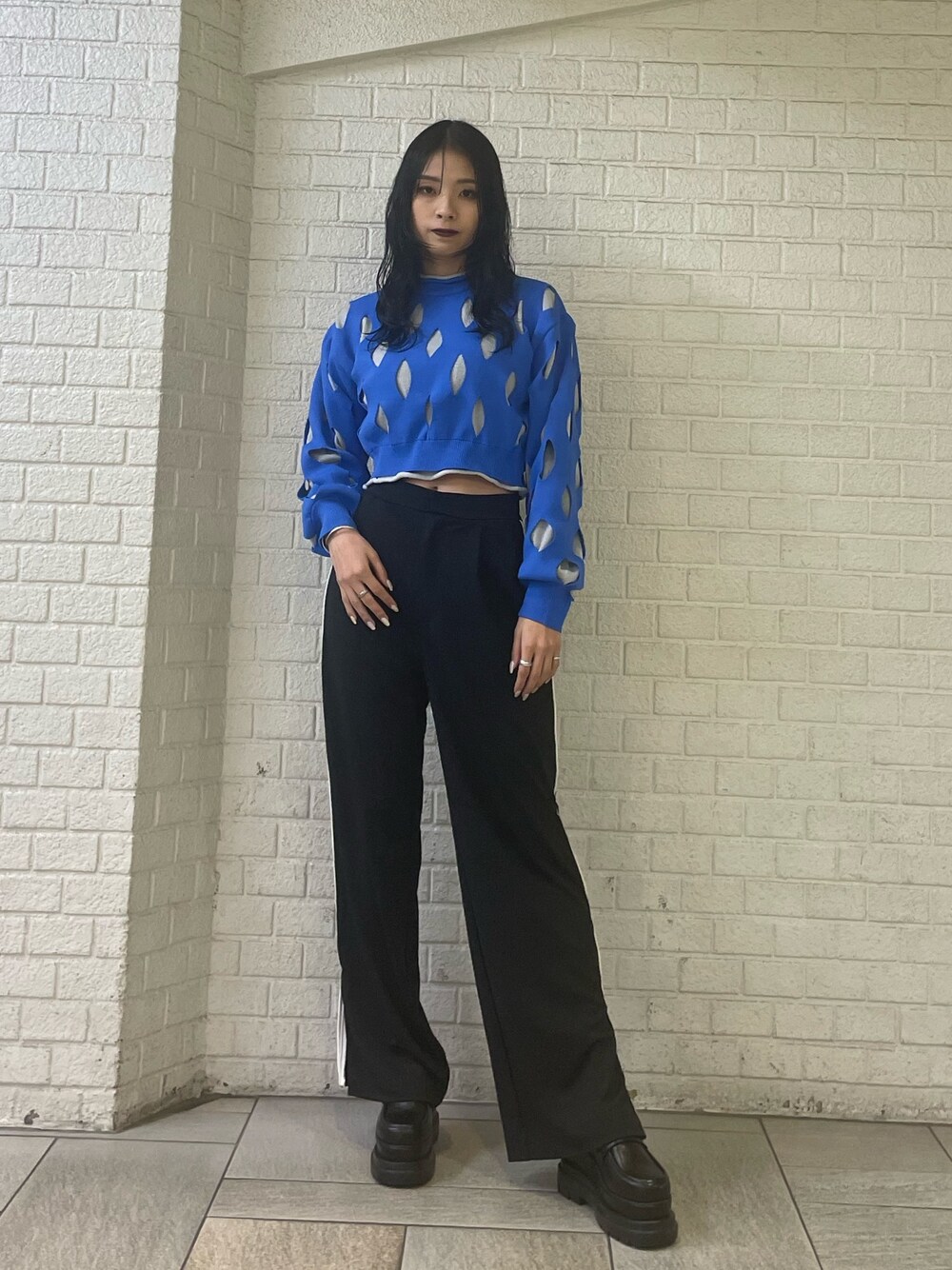 ブルー系のニット/セーター、ブラック系のスラックス、ブラック系のローファーを着用したレディースの冬コーディネートの1枚目の写真