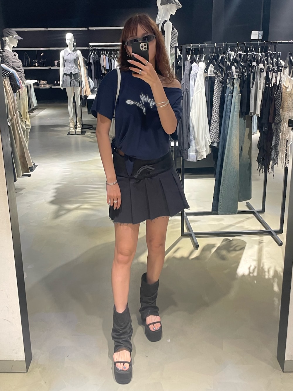 ブルー系のTシャツ/カットソー、グレー系のスカート、ブラック系のサンダルを着用したレディースの春コーディネートの1枚目の写真