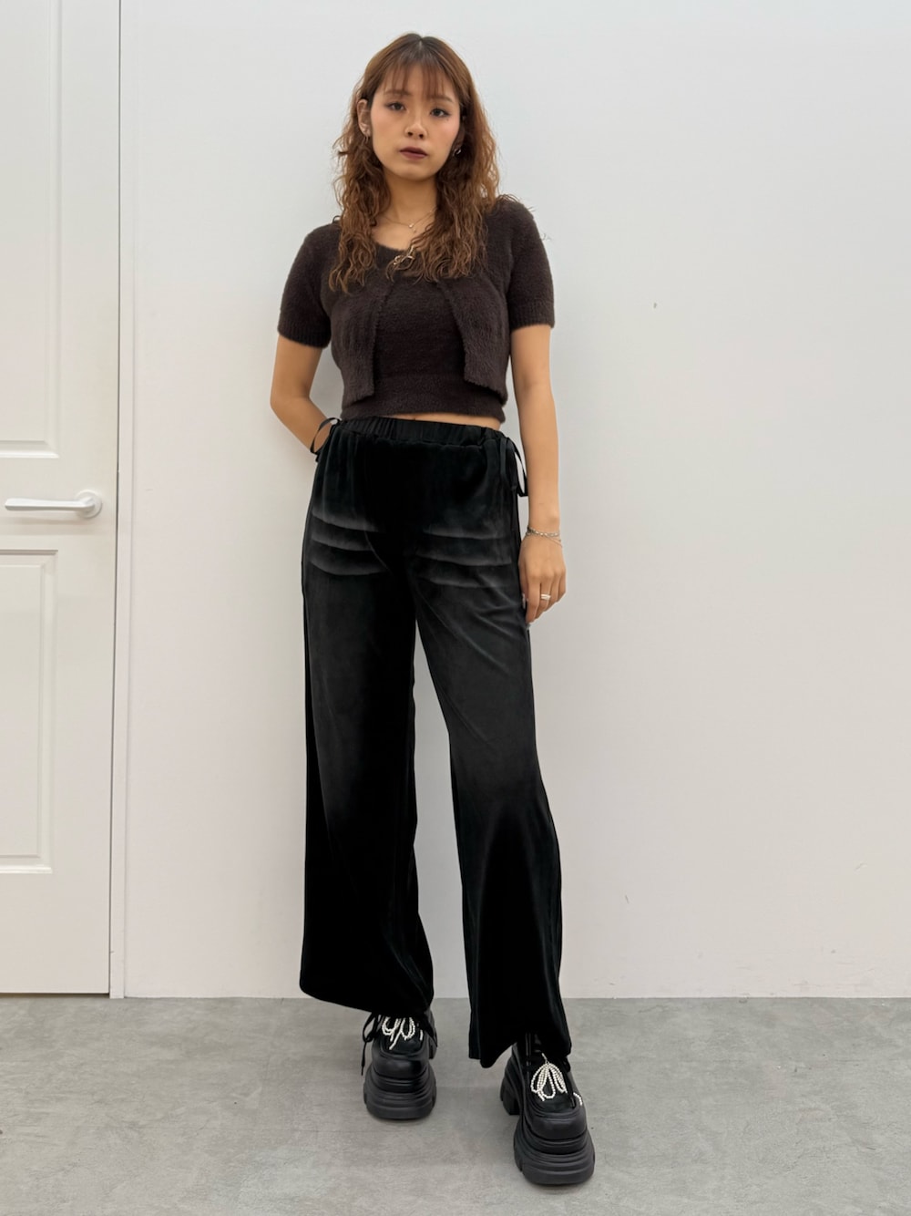 ブラウン系のニット/セーター、ブラック系のその他パンツ、ブラック系のローファーを着用したレディースの夏コーディネートの1枚目の写真