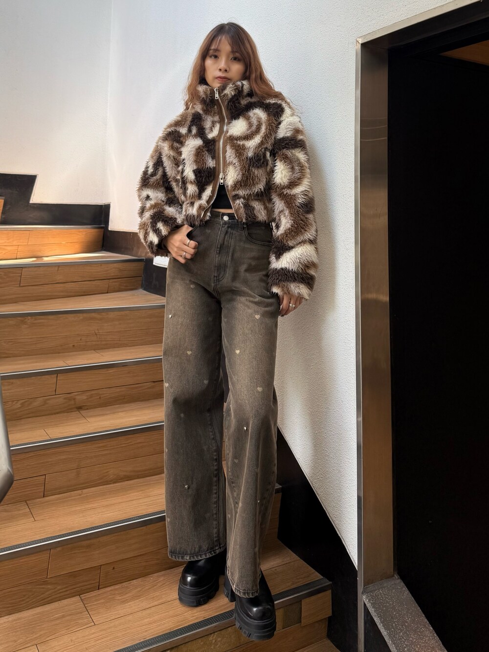 ブラウン系のブルゾン、ブラック系のニット/セーター、ブラウン系のデニムパンツを着用したレディースの秋コーディネートの1枚目の写真