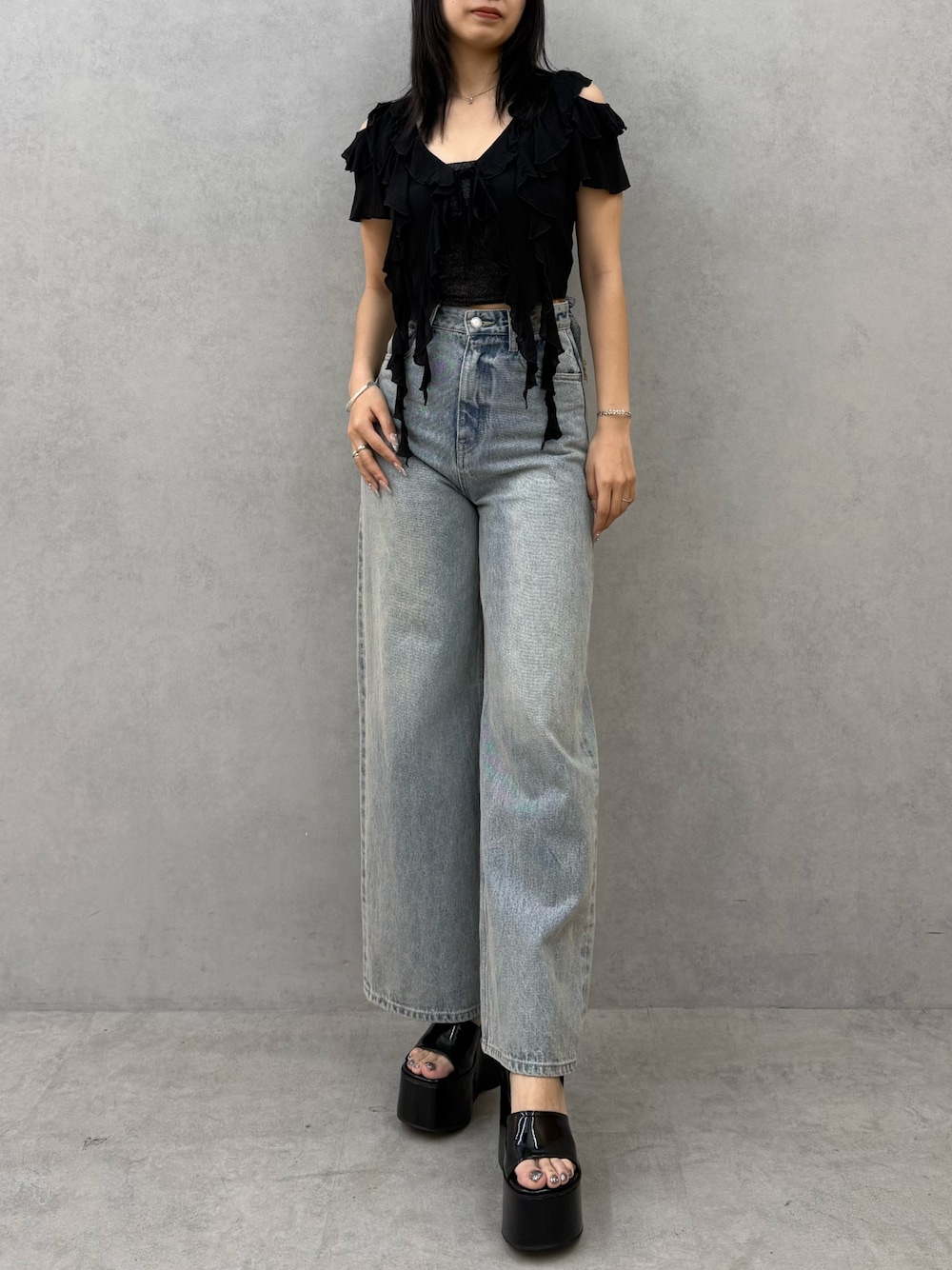 ブラック系のTシャツ/カットソー、ブラック系のキャミソール、ブルー系のデニムパンツを着用したレディースの春コーディネートの1枚目の写真