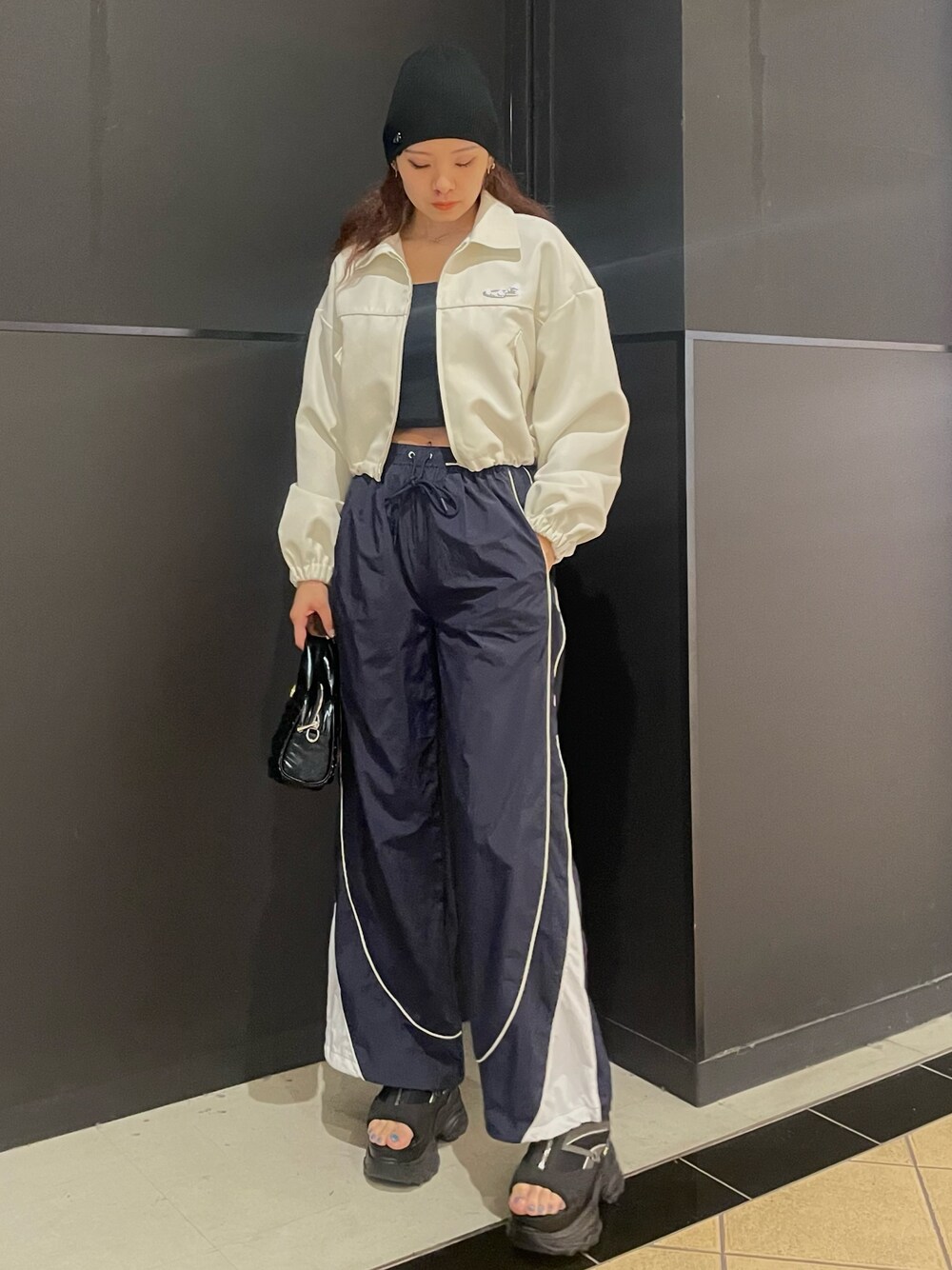 ブラック系のTシャツ/カットソー、ホワイト系のブルゾン、ブルー系のその他パンツを着用したレディースの春コーディネートの1枚目の写真