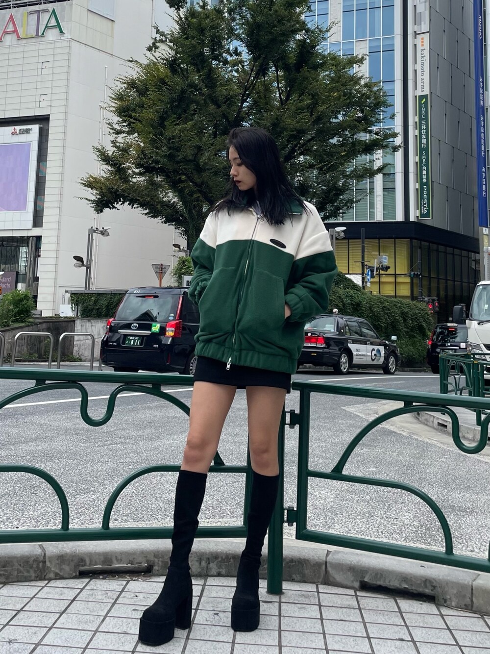 グリーン系のブルゾン、ブラック系のスカート、その他のブーツを着用したレディースの秋コーディネートの1枚目の写真