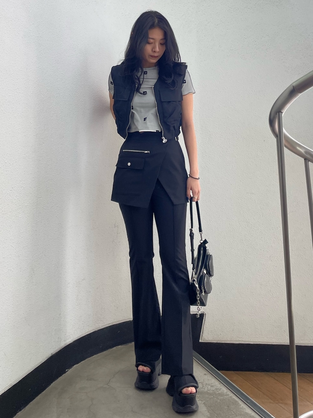 ホワイト系のTシャツ/カットソー、ブラック系のベスト、ブラック系のその他パンツを着用したレディースの春コーディネートの1枚目の写真