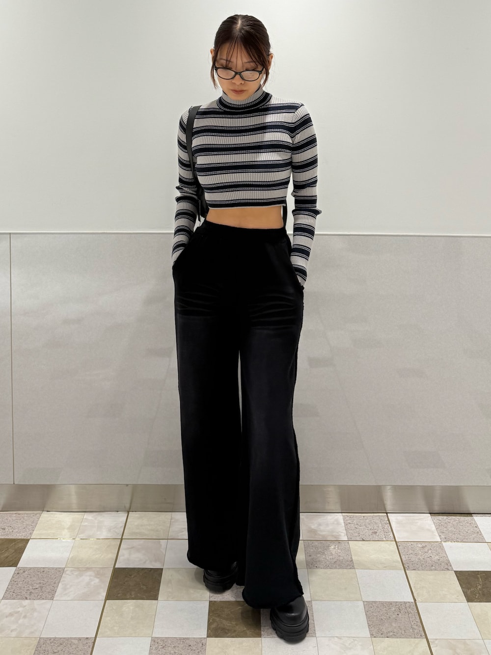 グレー系のニット/セーター、ブラック系のスウェットパンツ、ブラック系のブーツを着用したレディースの秋コーディネートの1枚目の写真