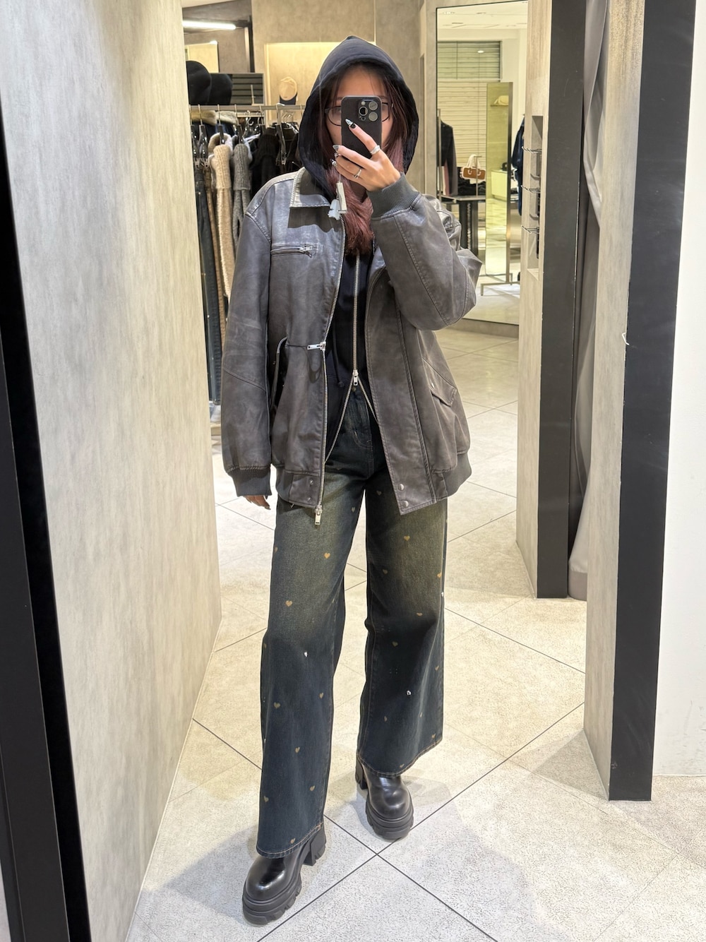 ブラック系のパーカー、グレー系のブルゾン、ブルー系のデニムパンツを着用したレディースの秋コーディネートの1枚目の写真