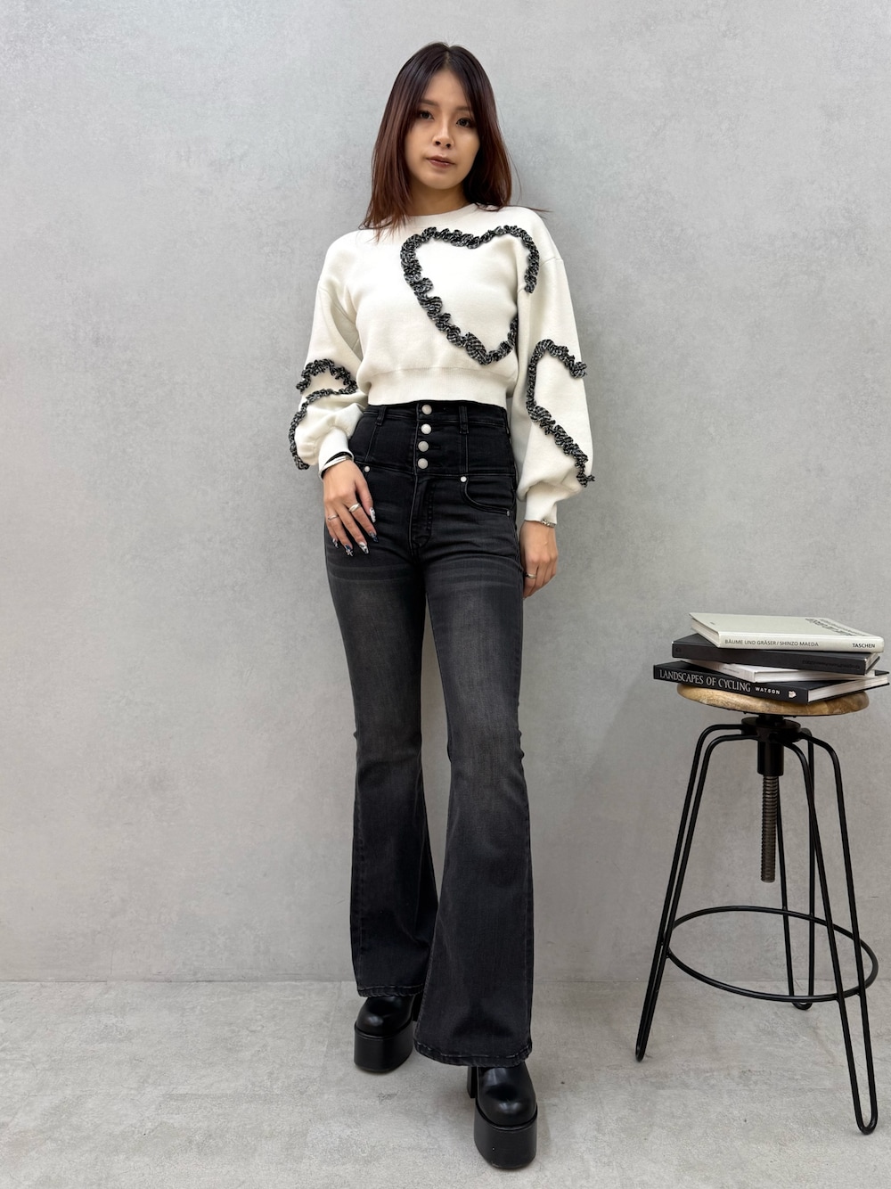 ブラック系のブーツ、ブラック系のデニムパンツ、ホワイト系のニット/セーターを着用したレディースの冬コーディネートの1枚目の写真