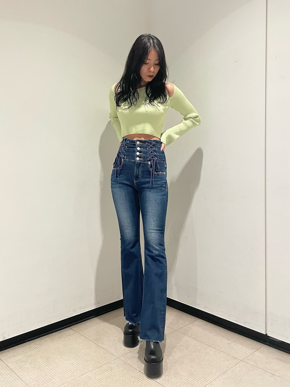 グリーン系のニット/セーター、ブルー系のデニムパンツ、ブラック系のブーツを着用したレディースの冬コーディネートの1枚目の写真