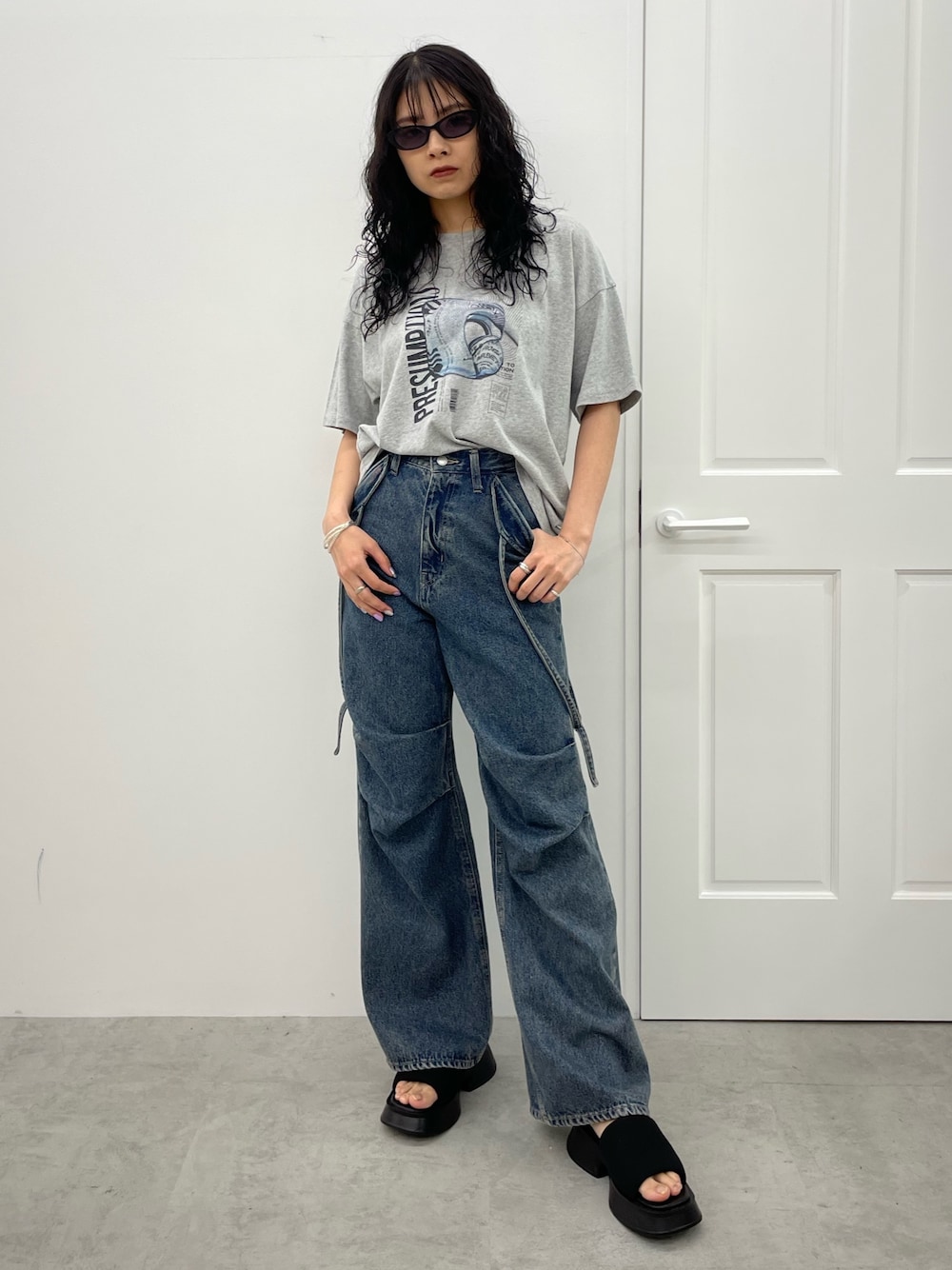 グレー系のTシャツ/カットソー、ブルー系のデニムパンツ、ブラック系のサンダルを着用したレディースの春コーディネートの1枚目の写真