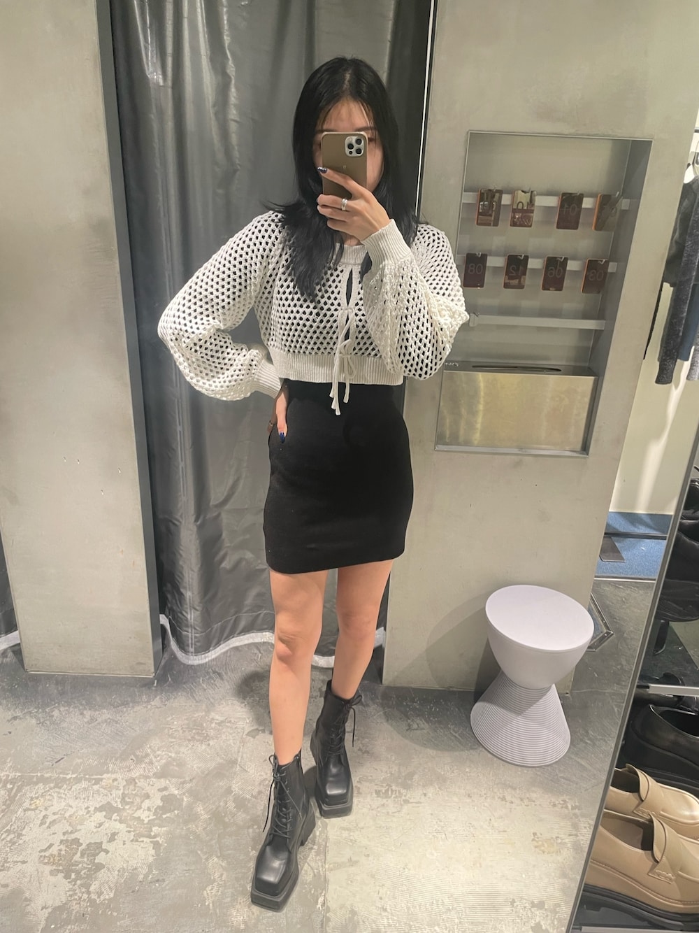 ホワイト系のワンピース、ブラック系のブーツを着用したレディースの冬コーディネートの1枚目の写真