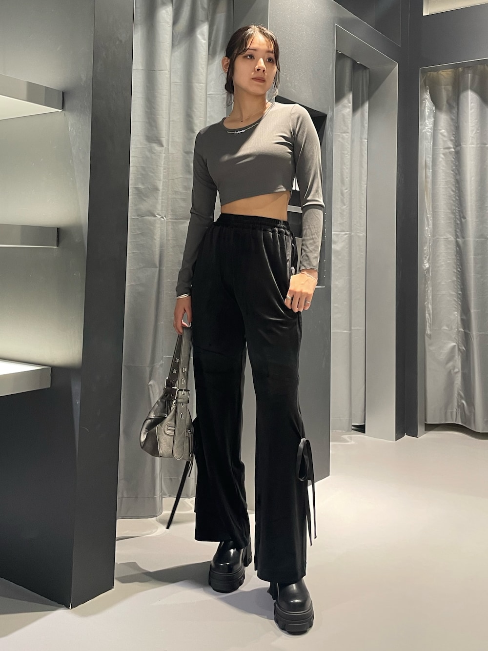 ブラック系のその他パンツ、シルバー系のハンドバッグ、ブラック系のブーツを着用したレディースの秋コーディネートの1枚目の写真