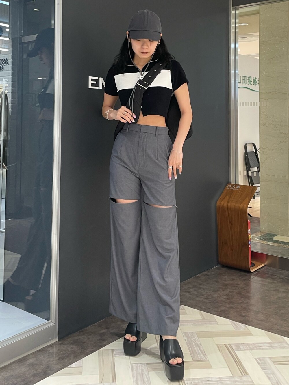 ブラック系のTシャツ/カットソー、グレー系のその他パンツ、ブラック系のサンダルを着用したレディースの春コーディネートの1枚目の写真